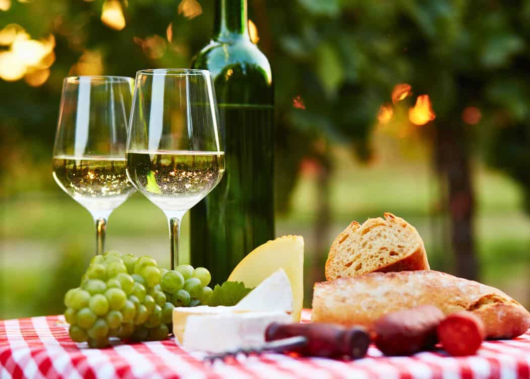 Glasses of white wine with bread and cheese